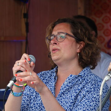 Sängerin mit Brille singt ins Mikrofon, secret stage, Kieler Woche 2023