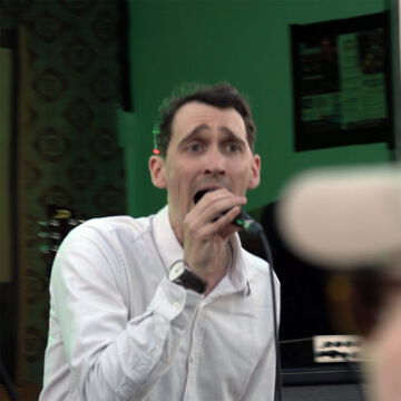 Sänger im weißen Hemd singt leidenschaftlich ins Mikrofon, secret stage, Kieler Woche 2026