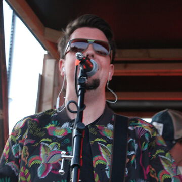 Sänger mit Sonnenbrille und gemustertem Hemd am Mikrofon, secret stage, Kieler Woche 2024
