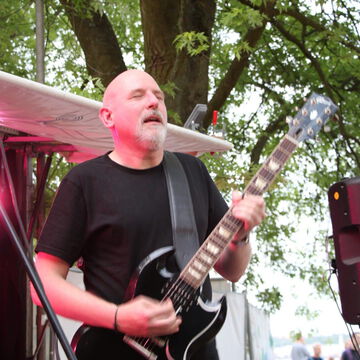 Gitarrist mit Glatze an der E-Gitarre auf der Bühne des Offenen Kanals, secret stage, Kieler Woche 2023