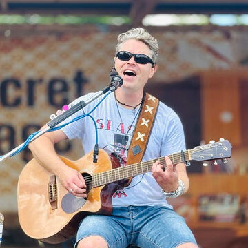 Sänger mit Sonnenbrille spielt Akustikgitarre auf der secret stage, Kieler Woche 2025