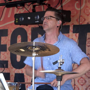 Schlagzeuger mit Brille im hellblauen Hemd am Becken, secret stage, Kieler Woche 2026