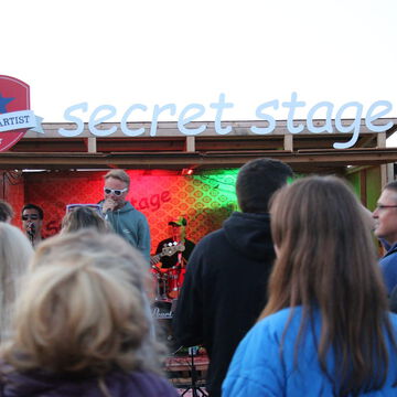 Publikum vor der secret stage mit grün-rotem Bühnenlicht, Kieler Woche 2024