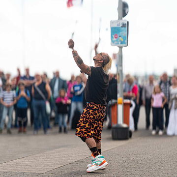 Straßenkünstler jongliert vor Publikum an der Kiellinie, Kiel Artist, Kieler Woche 2025
