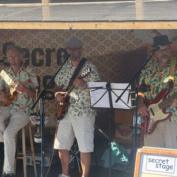 Band in Hawaiihemden mit Gitarren und Bass auf der secret stage, Kieler Woche 2025