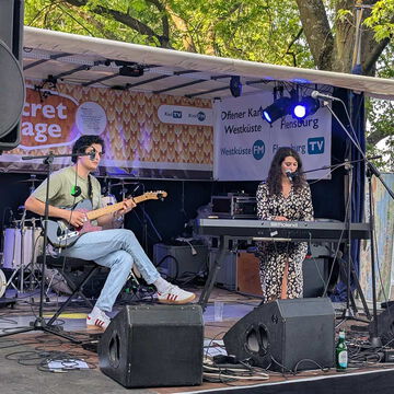 Gitarrist und Sängerin am Keyboard auf der Bühne des Offenen Kanals, secret stage, Kieler Woche 2025